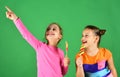 Children eat big colorful sweet caramels. Sisters with lollipops.