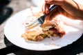 Children eating cheese and cherry strudel with sugar on top.