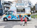 Children eating ice cream near an iceream truck