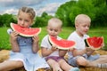 Children eating watermelon sitting on the grass Royalty Free Stock Photo