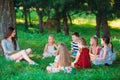 Children and education, young woman at work as educator reading book to boys and girls in park. Royalty Free Stock Photo