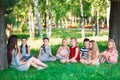 Children and education, young woman at work as educator reading book to boys and girls in park. Royalty Free Stock Photo