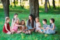 Children and education, young woman at work as educator reading book to boys and girls in park. Royalty Free Stock Photo