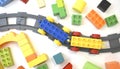 Children educational background with toy train, railway, plastic and wooden blocks on white. Royalty Free Stock Photo