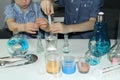 Children, elementary school boys, conduct chemical experiments with colored liquids in glass flasks, a scientific concept. 4k slow Royalty Free Stock Photo