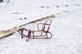 Children empty coaster is standing on snow in park in winter sunny day. Time for fun and happiness. Family time passing Royalty Free Stock Photo