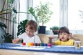 Children engaged in creativity in the home interior. Child draws and colors the picture with paints and a brush