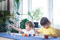 Children engaged in creativity in the home interior. Child draws and colors the picture with paints and a brush