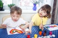 Children engaged in creativity in the home interior. Child draws and colors the picture with paints and a brush