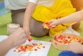 Children are engaged in creativity. Multi-colored pieces of paper cut into squares in the hands of children Royalty Free Stock Photo