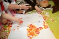 Children are engaged in creativity. Multi-colored pieces of paper cut into squares in the hands of children Royalty Free Stock Photo