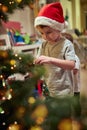 A little boy decorating a Christmas tree with his mother at home. Together, New Year, family, celebration Royalty Free Stock Photo