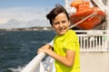 Children, experience ride on a ferry on a fjord, strong wind on the deck of a ferry on sunny day