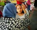 Children face painting. Artist painting little girl at the shop