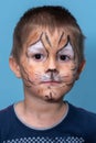 Children face painting. Boy painted as tiger or ferocious lion by make up artist. Preparing for theatrical performance. Boy actor Royalty Free Stock Photo