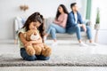 Children And Family Conflicts Concept. Little Girl Sitting Upset After Parents Argue Royalty Free Stock Photo