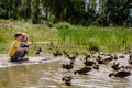 Children feeding ducks on abandoned lake. Royalty Free Stock Photo