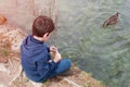 Children feeding geese in the pond. Caring for animals. Royalty Free Stock Photo