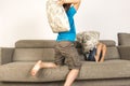 Children fighting together with pillows