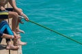 Children are fishing on the pier. Close-up of hands and rods Royalty Free Stock Photo