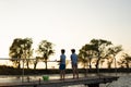 children with fishing rods stand on a wooden pier and fish at the lake. Fishing Royalty Free Stock Photo