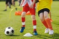 Children football soccer training scene. Football training for kids. Two boys happily chasing the football on grass training field Royalty Free Stock Photo