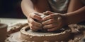 Children forming something on a potters wheel with brown clay