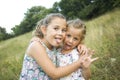 Children friend girls playing whispering on flowers grass in vac