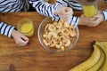 Children with fruit chips and orange juice