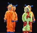 Children in funny colored overalls aliens dancing on stage