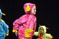 Children in funny colored overalls aliens dancing on stage