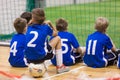 Children futsal team. Group of young indoor soccer players sitting together.