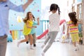 Children games in playroom. Kids play and run.