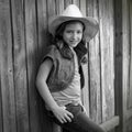 Children girl as kid cowgirl posing on wooden fence Royalty Free Stock Photo