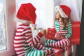 Children girl and boy is sad on Christmas morning by the window Royalty Free Stock Photo