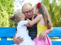 Children girl kissing her father, happy family portrait, group of three peoples sit on bench, parenting concept Royalty Free Stock Photo