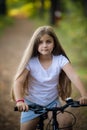 Children girl riding bicycle outdoor in forest smiling. Royalty Free Stock Photo