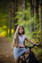 Children girl riding bicycle outdoor in forest smiling. Royalty Free Stock Photo