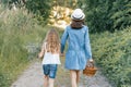 Children girls on forest road holding hands. Sunny summer day, girl holding basket with berries Royalty Free Stock Photo