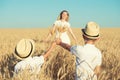 Children give their mother bouquet of spikelets in a wheat field.