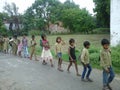 Children going to school in row with motivator in india.