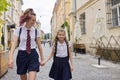 Children going to school, two girls sisters walking together, holding hands