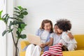 Children and grandmother playing cheerfully in living room, Mother and little children sitting on couch using laptop, boy holding Royalty Free Stock Photo