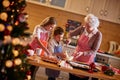 Children and grandmother preparing Christmas cookies