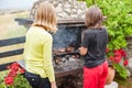 Children grilling meat. Boy and girl making barbecue in nature Royalty Free Stock Photo