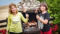 Children grilling meat. Boy and girl making barbecue in nature Royalty Free Stock Photo