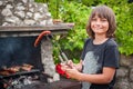 Children grilling meat. Happy teenage boy making barbecue in nature Royalty Free Stock Photo