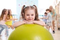 Children in the gym. Preschool girl with fitball in physical education lesson.