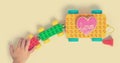 Children hand pulling colorful love train toy block