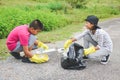 Children hand in yellow gloves picking up empty of bottle plastic into bin bag Royalty Free Stock Photo